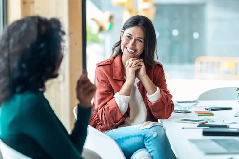 Due donne sorridenti durante una sessione di coaching professionale, simbolo di fiducia, ascolto empatico e crescita personale nel percorso per diventare coach professionista