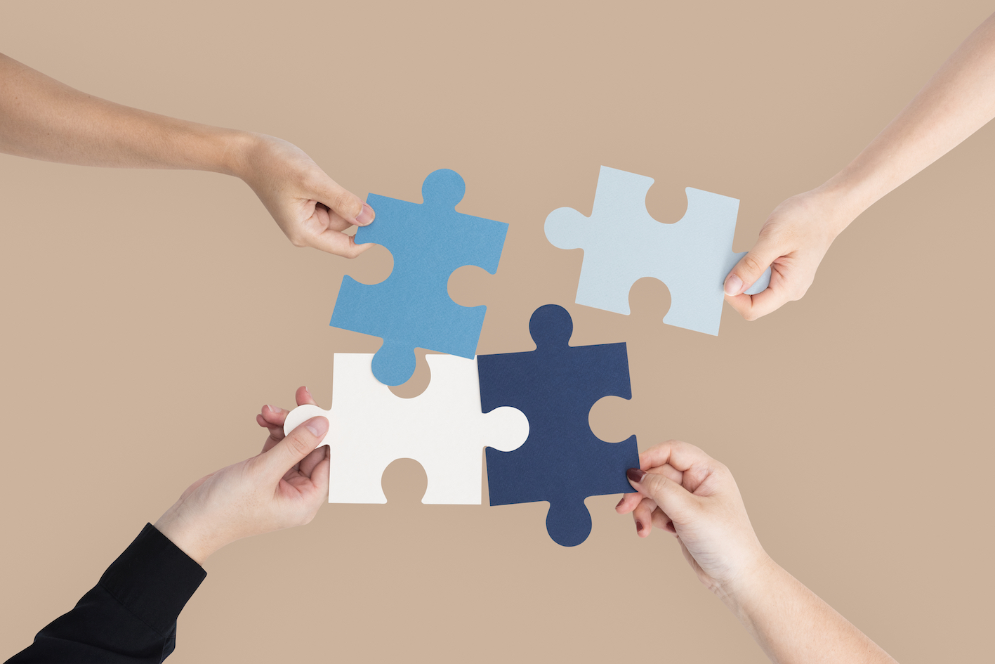 Collaborazione tra partner che uniscono competenze e valori come pezzi di un puzzle per la formazione in coaching professionale