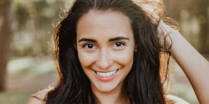 Donna sorridente che guarda con fiducia davanti a sé, simbolo di autostima, consapevolezza e miglioramento personale attraverso strategie di coaching efficaci