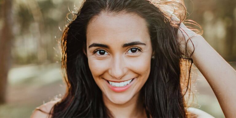 Donna sorridente che guarda con fiducia davanti a sé, simbolo di autostima, consapevolezza e miglioramento personale attraverso strategie di coaching efficaci